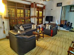 Sala de estar con 2 sofás de cuero y TV en Dickwella Green Villa, en Dikwella