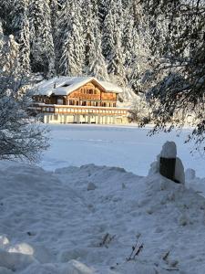 a large wooden house in the snow with trees at Chalet Familial Sublime in Crans-Montana