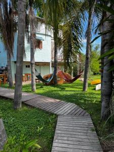 a hammock in a yard with trees and a house at Hidden Island Hostel in Tigre