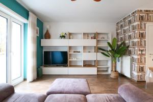 - un salon avec un canapé et une télévision dans l'établissement Mila Apartments Battista, à Milan