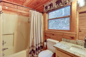 a bathroom with a toilet and a shower and a window at Waterfront Cabin with Beautiful River View and Hot Tub in Ellijay +24 photos