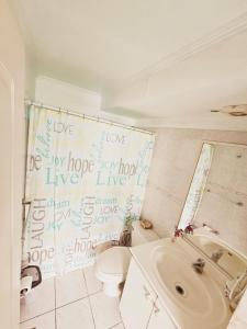 a bathroom with a shower curtain with writing on it at Departamento en Playa Brava Iquique 1 dormitorio 1 baño in Iquique