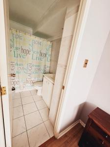 un baño con aseo y una pared con escritura. en Departamento en Playa Brava Iquique 1 dormitorio 1 baño, en Iquique