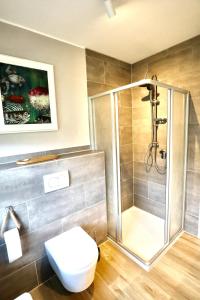 ネスマージールにあるNessmersiel, Renovierte Erdgeschosswohnung mit Garten, in Deichnähe, Wallbox,のバスルーム(シャワー、白いトイレ付) +18枚の写真