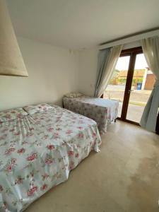 a bedroom with a bed and a table and a window at Taiba Beach Resort Casa com piscina in Taíba +36 photos