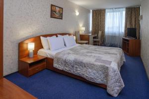 a hotel room with a large bed and a desk at Cherkasy Palace in Cherkasy