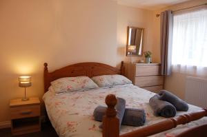 un dormitorio con una cama con dos animales de peluche en Netherleigh Family Bungalow in Pennal, en Pennal