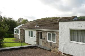 Casa blanca con techo marrón en Netherleigh Family Bungalow in Pennal, en Pennal