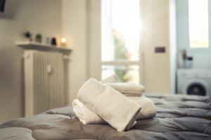 una pila de toallas sentadas encima de una cama en BnB Il Bicciolano, en Vercelli
