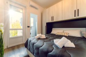 1 dormitorio con 1 cama grande y toallas. en BnB Il Bicciolano, en Vercelli