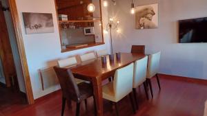 a dining room with a wooden table and chairs at Infinity Mountain View in Angoustrine