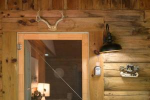 Habitación con pared de madera, puerta y lámpara. en Couples Getaway Cabin near National Park w Hot Tub en Pigeon Forge