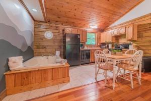 eine Küche und ein Esszimmer mit einer Badewanne und einem Tisch in der Unterkunft Couples Getaway Cabin near National Park w Hot Tub in Pigeon Forge