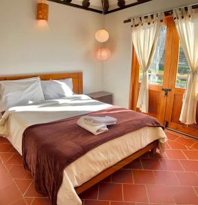 a bedroom with a bed with two towels on it at VILLA CHARLOTTE 2 en colombia in Villa de Leyva
