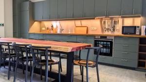 eine Küche mit einem Holztisch und Stühlen in der Unterkunft L'ARONDE in Olloy-sur-Viroin