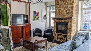 ein Wohnzimmer mit Sofa und Kamin in der Unterkunft L'ARONDE in Olloy-sur-Viroin