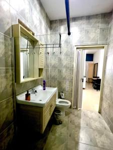 a bathroom with a sink and a toilet and a mirror at Dushi Apartments in Willemstad