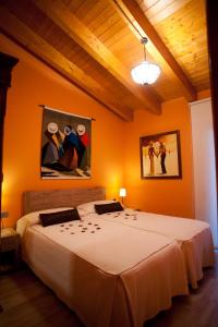 a bedroom with a large bed with orange walls at Hotel Villaro Del Bosc in Freixinet