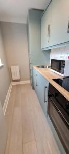 a kitchen with white cabinets and a sink and a microwave at Blima Central Rooms in Dublin