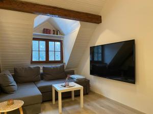 a living room with a couch and a flat screen tv at Großherzögliches Jägerhaus in Bensheim