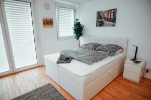 1 dormitorio blanco con 1 cama y 2 ventanas en Vienna Danube Apartment 45, en Viena
