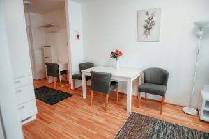 comedor con mesa blanca y sillas en Vienna Danube Apartment 45, en Viena