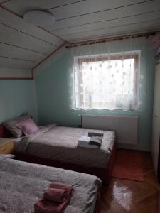 a bedroom with two beds and a window at Аpartman ELENA in Rakovac
