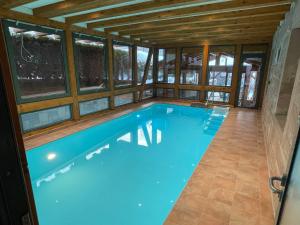 a large swimming pool in a house with windows at Apartment im Wald - mit Schwimmbad! 