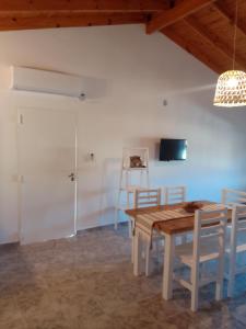 - une salle à manger avec une table et des chaises en bois dans l'établissement La Pausa, à Carhué
