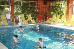 a group of people swimming in a swimming pool at Drei Quellen Hotel Kipper in Bad Gams