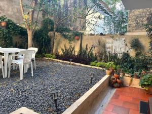 a patio with a table and chairs and plants at Casa Hotel El Encanto de Villa in Villa de Leyva