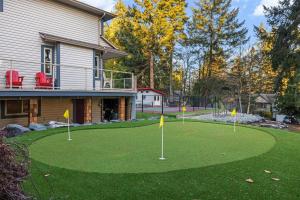 a golf course in front of a house with three put greens at Mountain Retreat in North Saanich