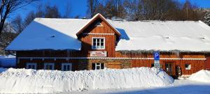 a house covered in snow in front at Penzion Pod Třešňovkou in Horní Maršov