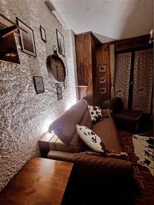 a living room with a couch and a clock on the wall at CHALET LAVANDA San Giacomo di roburent in San Giacomo