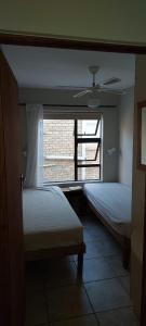 1 dormitorio con 2 camas y ventana en Toch Noch, en Hartenbos