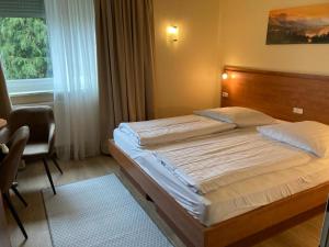 um quarto com uma cama, uma cadeira e uma janela em Hotel Oyten am Markt em Oyten