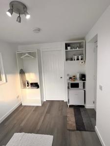 cocina blanca con estufa blanca horno superior en En-suite Room with Independent Entrance., en Edimburgo