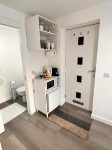 een witte keuken met een fornuis en een deur bij En-suite Room with Independent Entrance. in Edinburgh