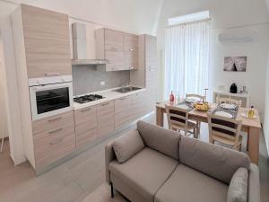 ein Wohnzimmer mit einem Sofa und eine Küche mit einem Tisch in der Unterkunft Donna Anna in Polignano a Mare