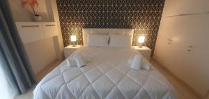 a bedroom with a large white bed with two night stands at Seaside Beauty 5 min Vouliagmeni Beach in Athens +57 photos