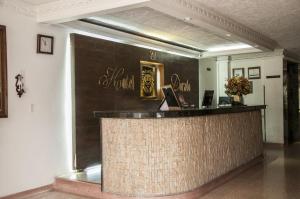 a hotel lobby with a reception counter withcriptions on the wall at Hotel León Dorado in Bucaramanga