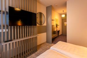 Hotel Erbenhof في فايمار: غرفة نوم مع تلفزيون بشاشة مسطحة على جدار