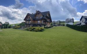 a large house on a large grass field at Willa Rembisz in Łapsze Niżne