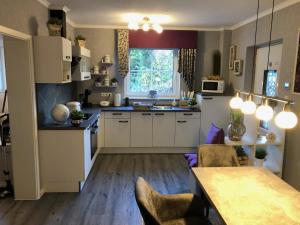 a kitchen with white cabinets and a table with chairs at Burgmoselblick in Burgen