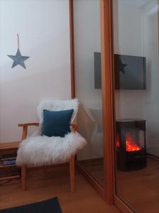 a white chair with a pillow in front of a mirror at Faschina Apartment - Top 1 in Fontanella