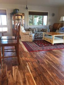 uma sala de estar com pisos em madeira, uma mesa e um sofá em Harbor House in Morro Bay em Morro Bay