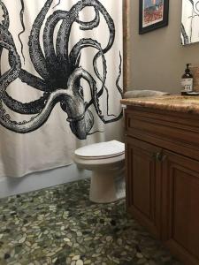 a bathroom with a toilet and an octopus shower curtain at Harbor House in Morro Bay in Morro Bay