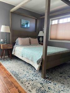 a bedroom with a four poster bed and a window at Harbor House in Morro Bay in Morro Bay