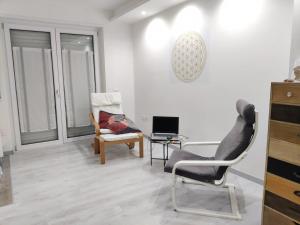 a living room with a chair and a desk with a laptop at Casa Akira in Riva del Garda
