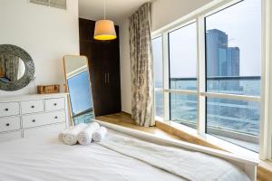 a bedroom with a bed and a large window at Veluxa - Stylish 2 Bed with View in Dubai